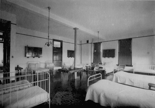 Beds line all four walls of a ward.
